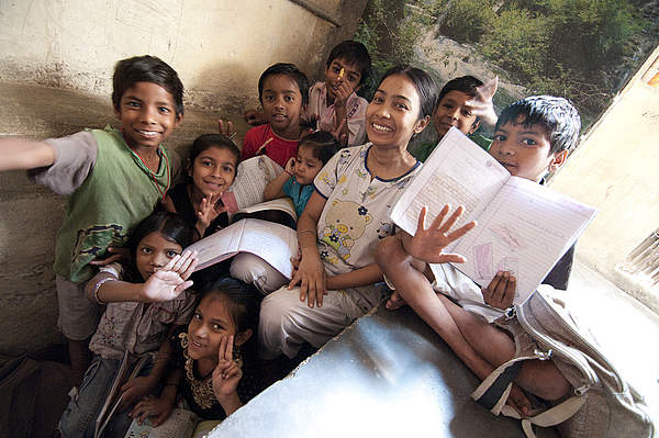 children in India launghing with books in their hands