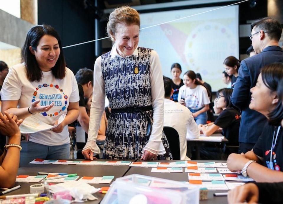 Image of the UNICEF Executive Director Henrietta H. Fore with young people at a table