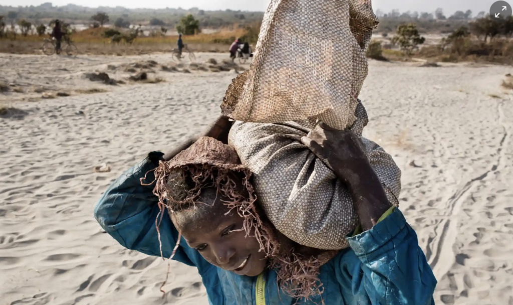 Image of a young child carrying cobalt from the mines