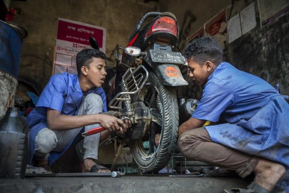 Image of youth repairing a motorcycle