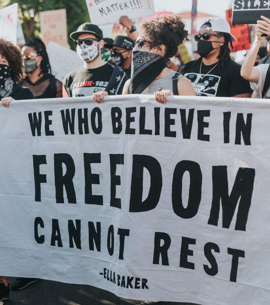 A photo of protesters holding a banner about freedom
