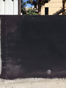 Black wall paint covering the mural of an LGBTQ activist