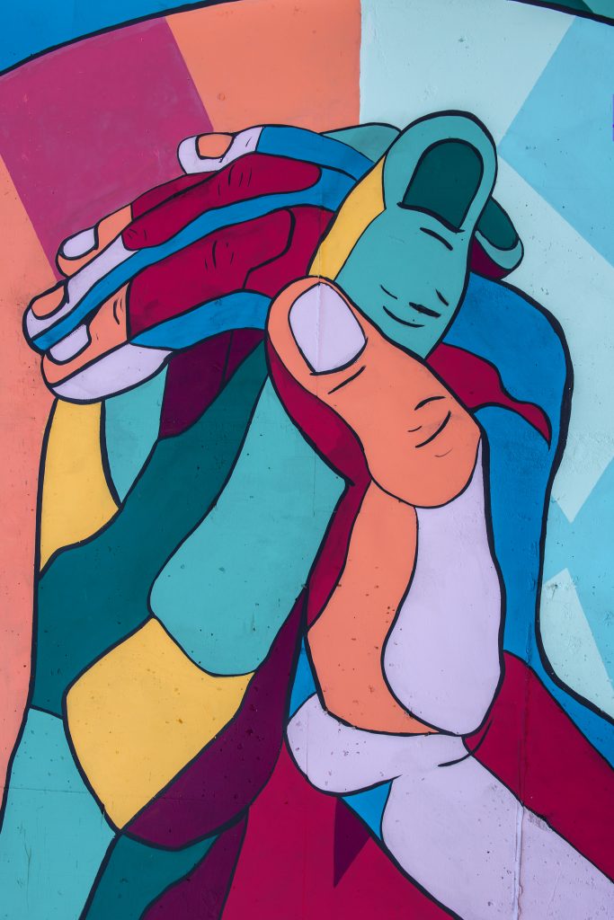 Image of hands holding together, representing cooperation and mutual understanding.