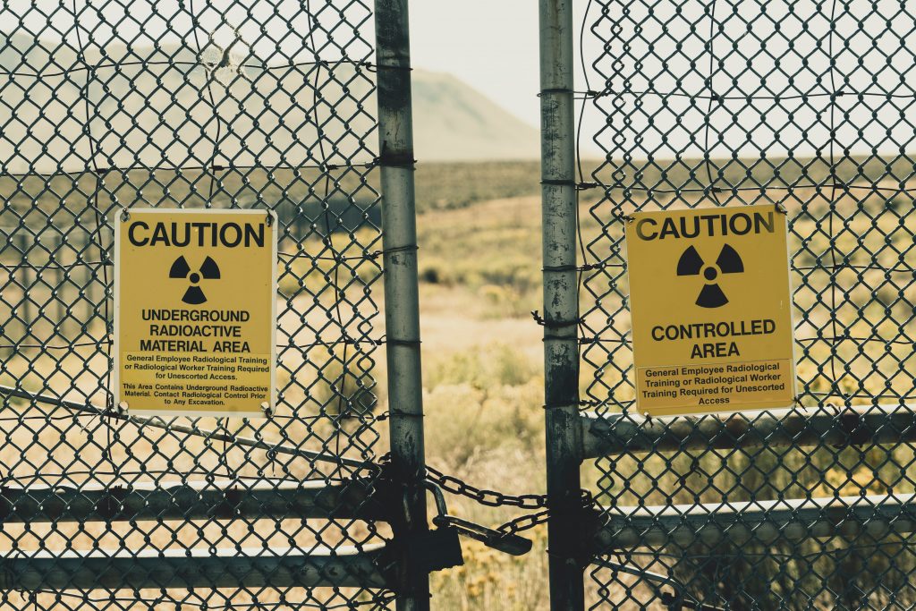 Photo of closed gate with a sign indicating caution due to radioactive material 