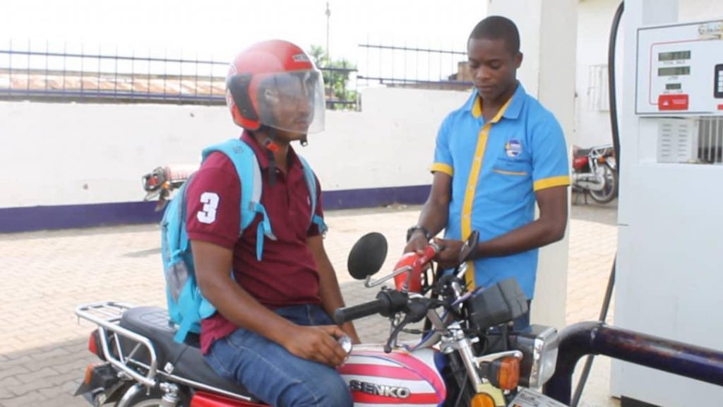 Image of Arafat putting gas in his motorcycle