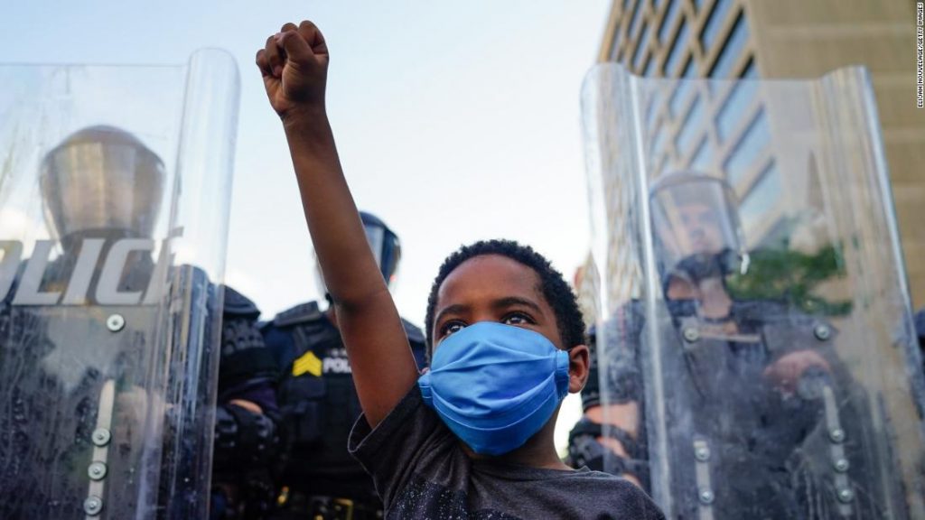 Little boy raising his fist in solidarity at a protest.