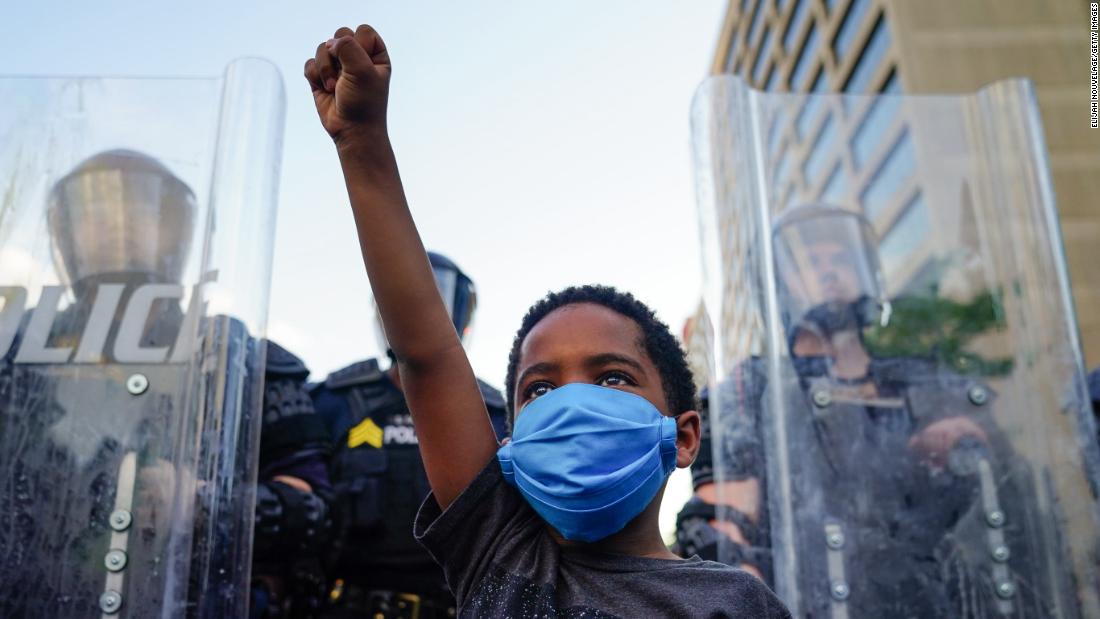 Little boy raising his fist in solidarity at a protest.