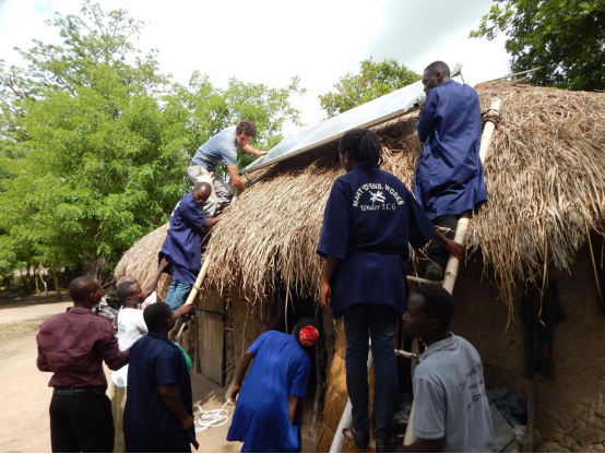 Some students of the centre undertaking a solar installation at Adaklu Gakukorpe.Julien, a volunteer from France can be seen guiding them.