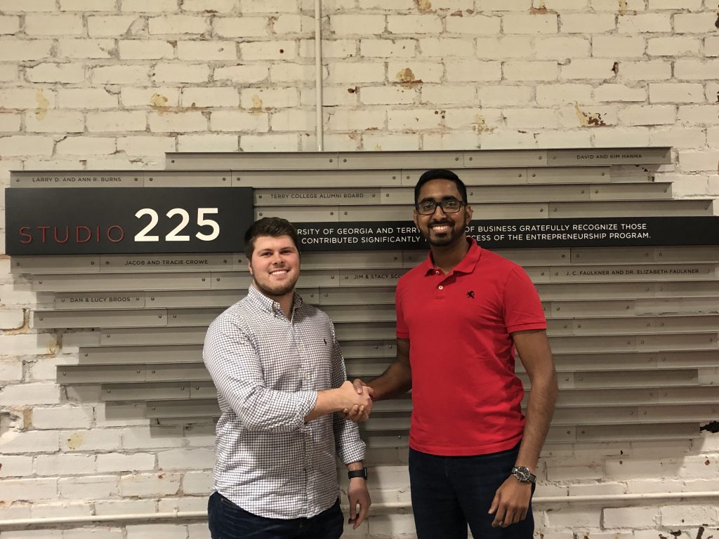 Nipuna Ambanpola (right) shaking hands with UGA Kickstarter Fund representative Casey Ridley (left) accepting $5,000 in support of IVolunteerNow.