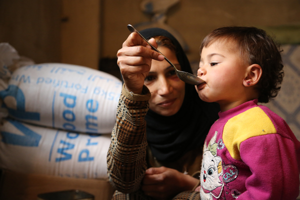 Image of a woman feeding a child.