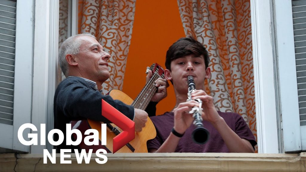 An older man playing the guitar, and a young man playing the clarinet. 