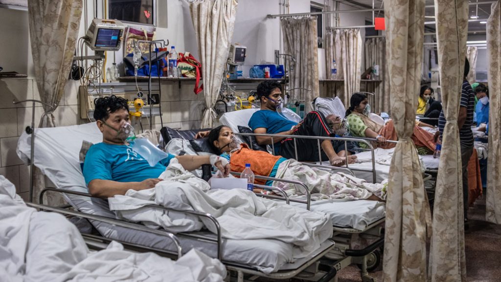 Hospital beds filled with Covid-19 patients wearing oxygen masks. 