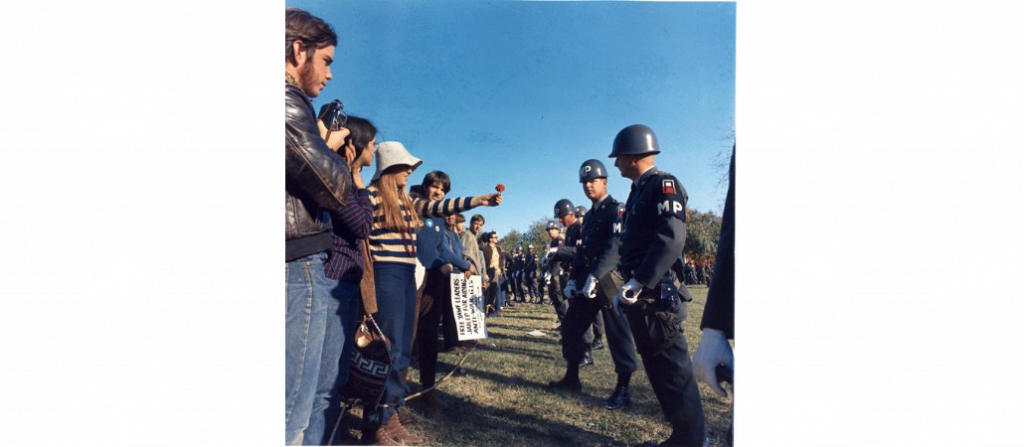 Photograph of a Female Demonstrator Offering a Flower to a Military Police Officer