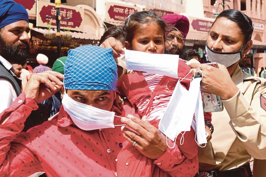 A group of people wearing face masks provided by an official. 