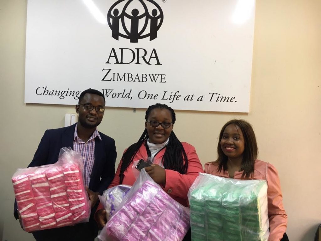 Sanitary Aid Zimbabwe volunteers handing over packs of disposable sanitary pads to ADRA Zimbabwe for onward transmission to victims of Cyclone Idai.