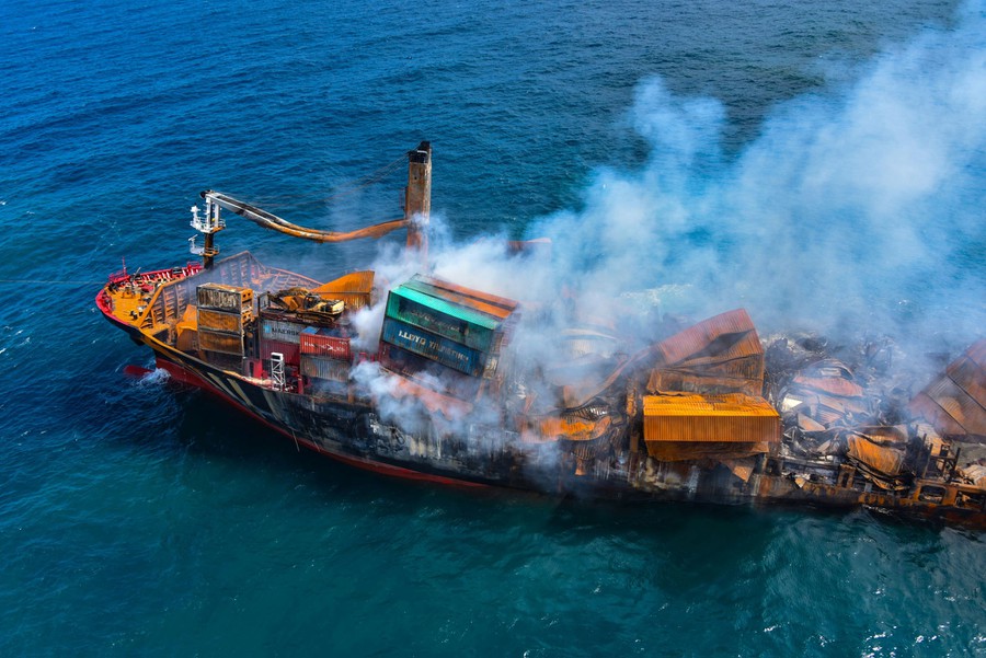 Smoke rises from a fire onboard the MV X-Press Pearl vessel as it sinks while being towed into deep sea off the Colombo Harbour, in Sri Lanka