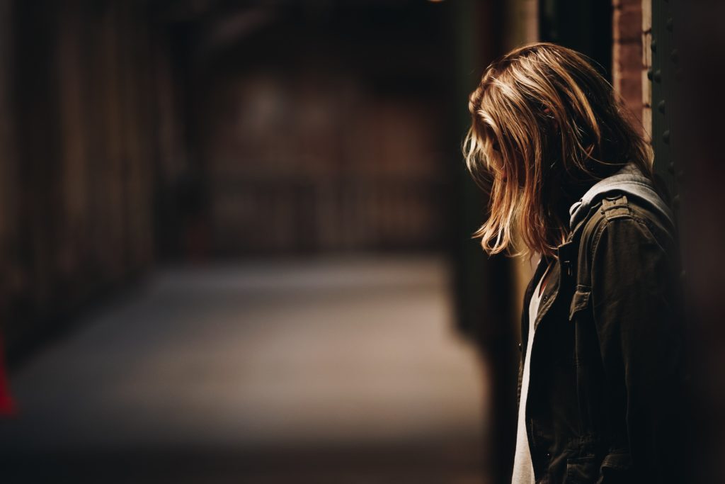 An image of a girl standing isolated and distressed.