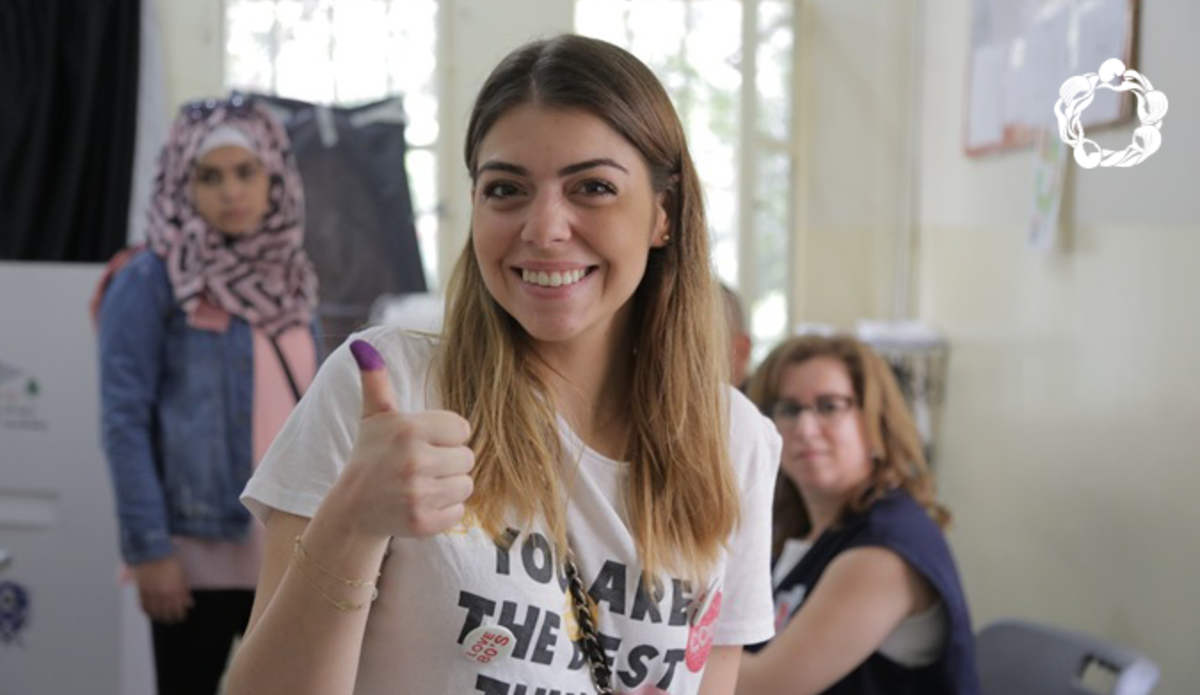 A Lebanese Women raising her thumbs up after voting.