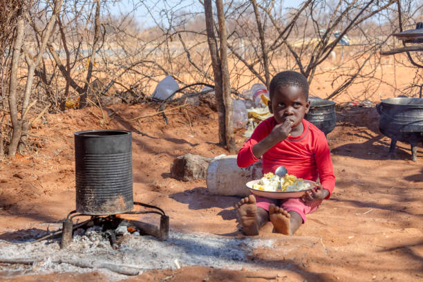 african child in a village near Kalahari desert, in the outdoors kitchen