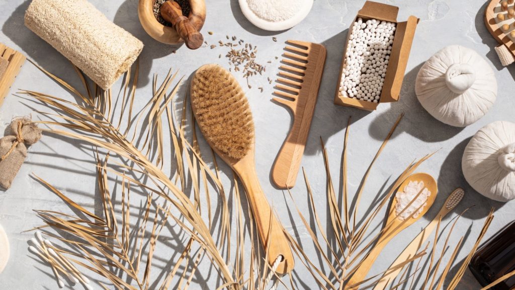 An image with sustainable products such as a wooden hairbrush, comb, salt, etc.