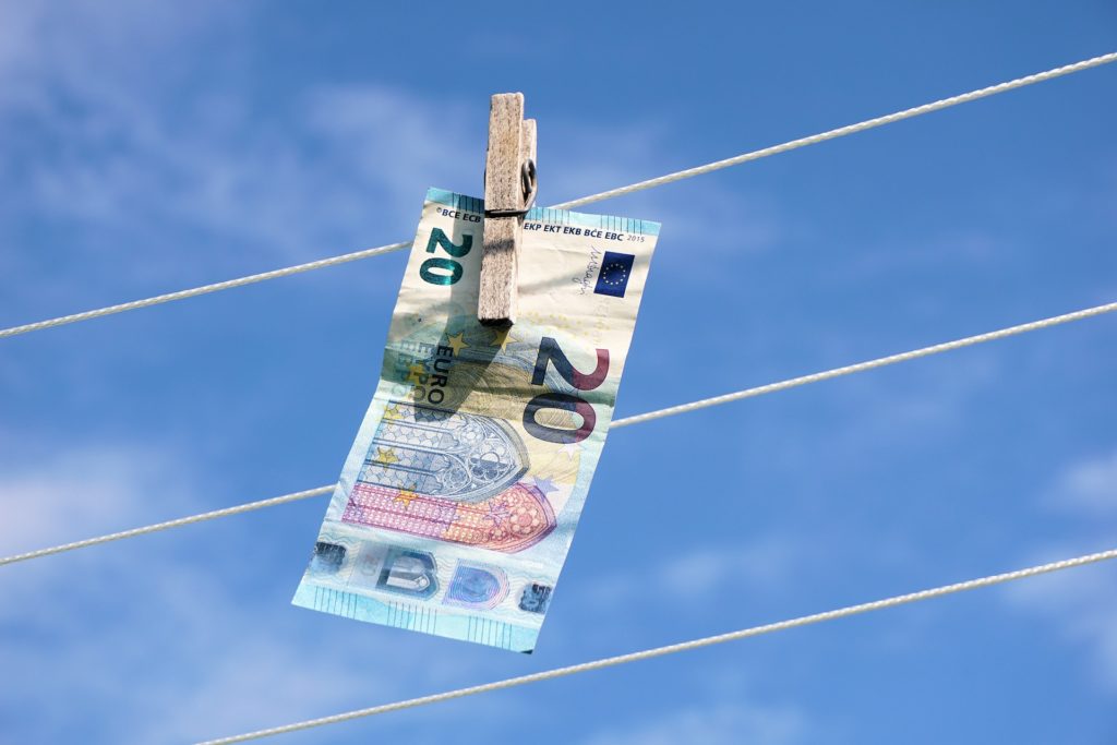 20 euro note pegged to a clothes line with a blue sky background, an image literal representation of 'money laundering'