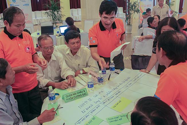 An discusses with participants and facilitators in a workshop