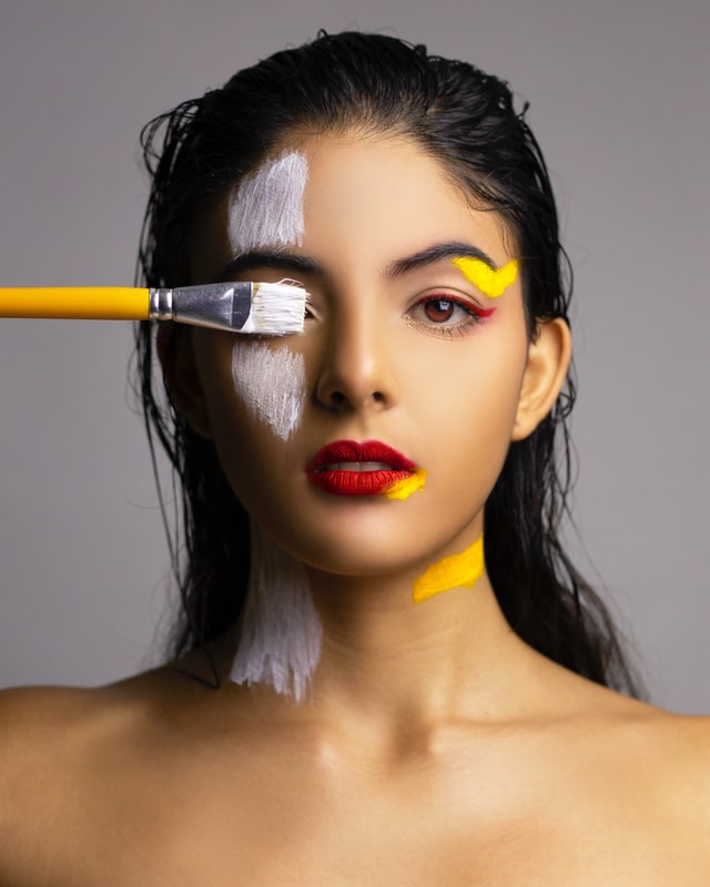 Woman with white paint over her face; symbolic of the craze behind skin whitening in the east.