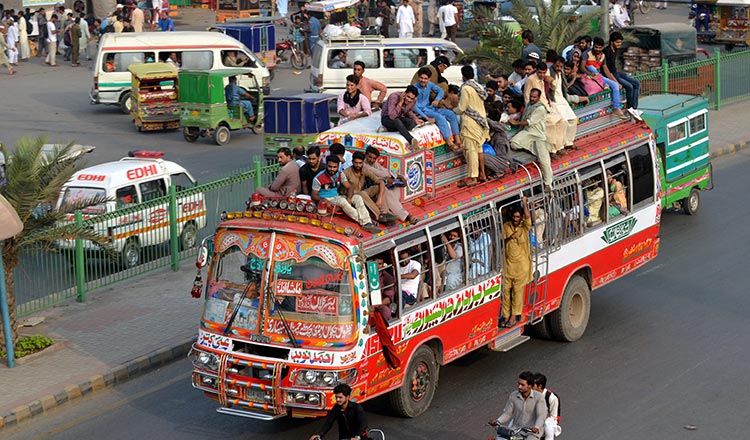 Image of people riding on public transport vehicles in Pakistan