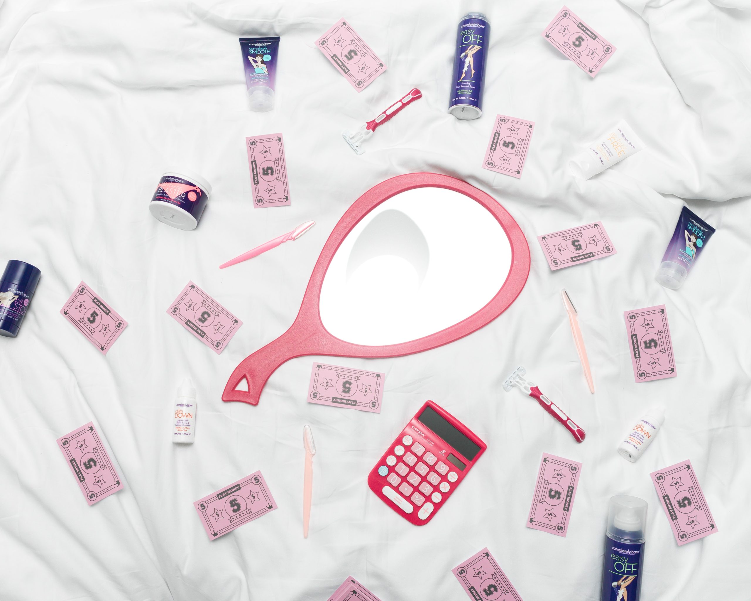 toiletry products for women with pink papers of money around to express pink tax