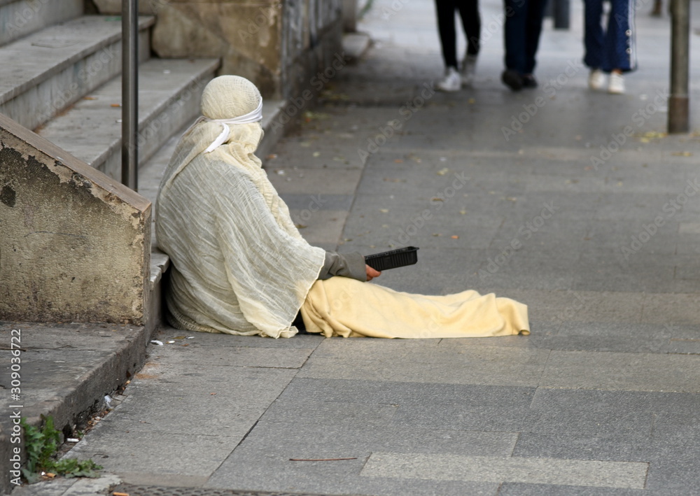 Photo showing a person on the streets begging for food.