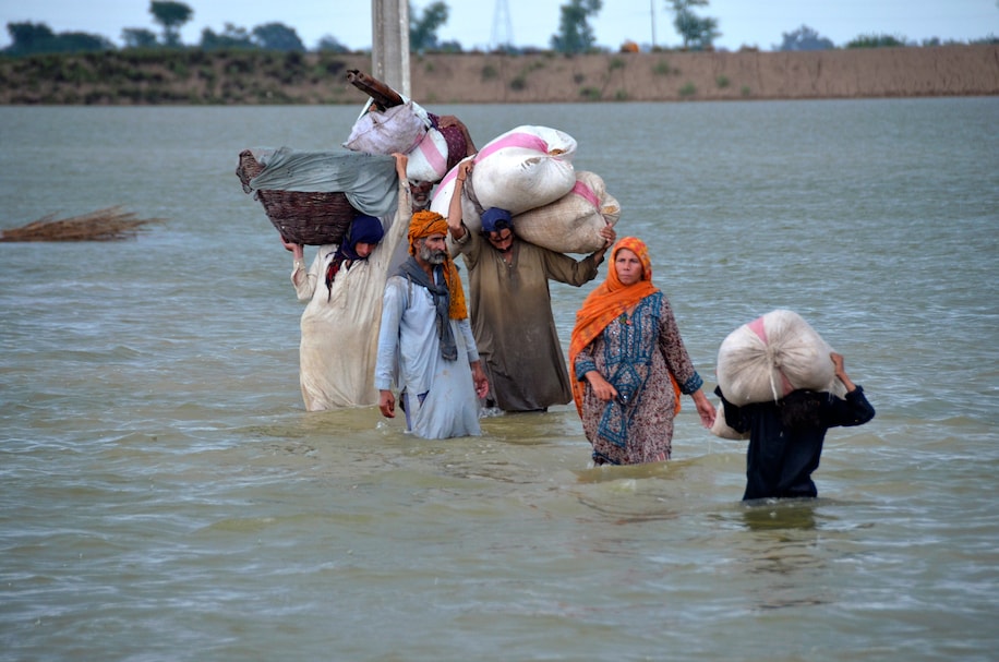 A family wades through the flood water with what little belongings they were able to salvage.