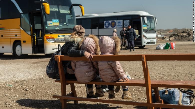 Woman refugee sitting together with her children